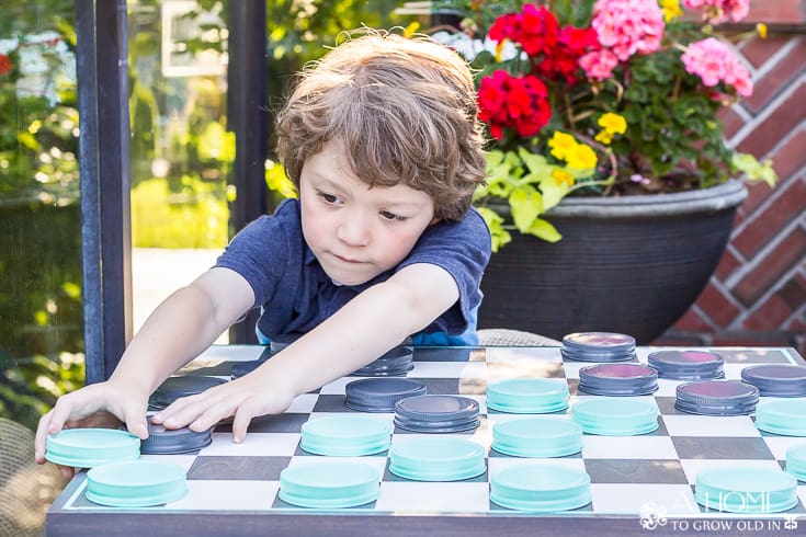 child playing on giant outdoor checkerboard
