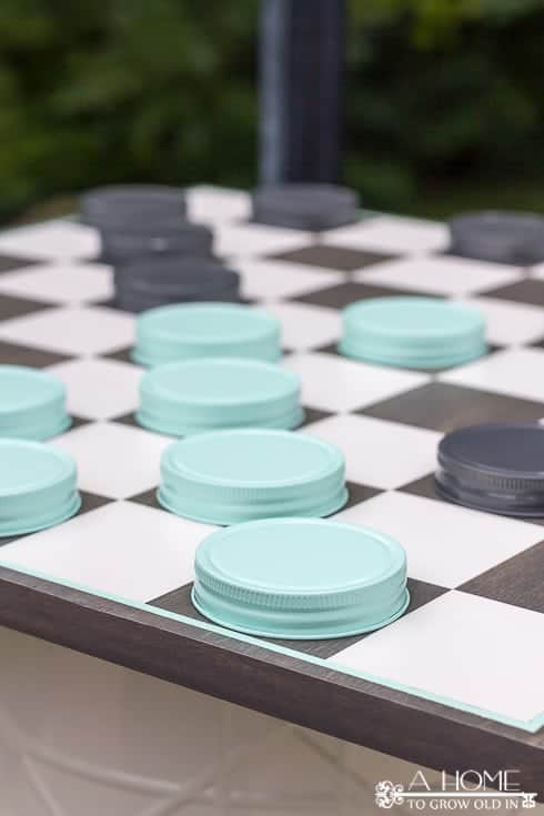checkerboard with mason jar game pieces set up to play