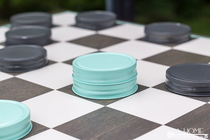 checkerboard with mason jar game pieces set up to play