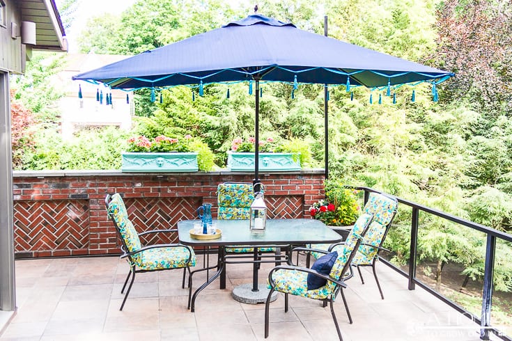 This tasseled outdoor umbrella is a great way to get a high-end look for less! It's an easy and inexpensive DIY that saved me over $800 off of the Frontgate version! Pin it now so you'll have it later!