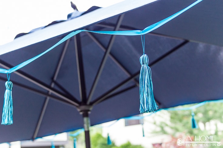 This tasseled outdoor umbrella is a great way to get a high-end look for less! It's an easy and inexpensive DIY that saved me over $800 off of the Frontgate version! Pin it now so you'll have it later!