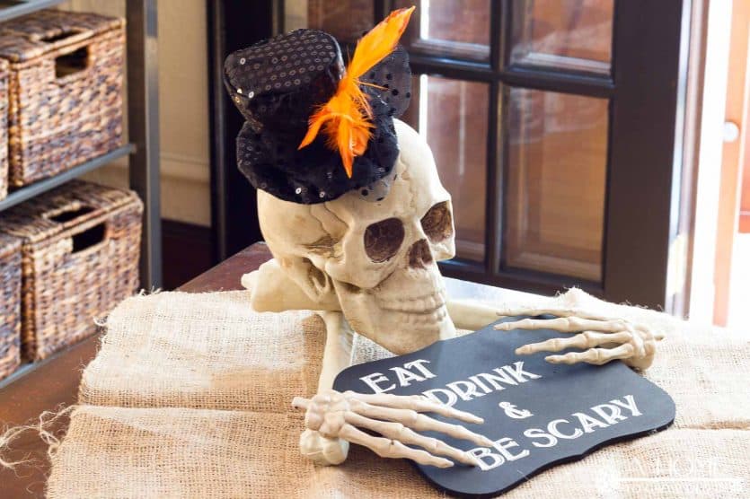 DIY halloween skull and bones centerpiece with eat drink and be scary sign