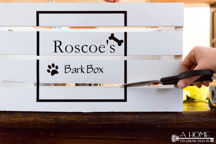 applying adhesive to a DIY wooden dog toy bin