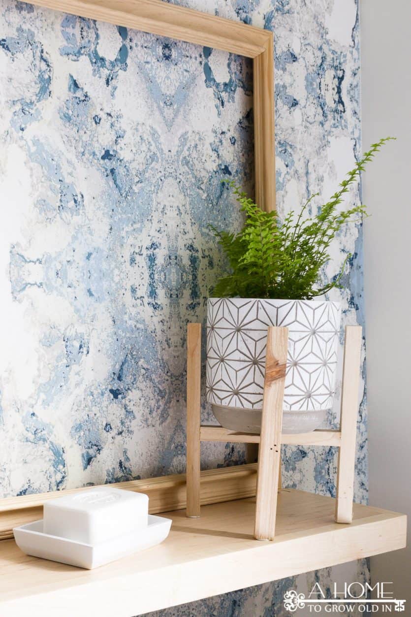 bathroom shelf with modern plant stand and anthropology wallpaper