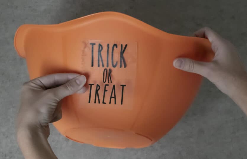 placing adhesive vinyl design on Halloween candy bowl