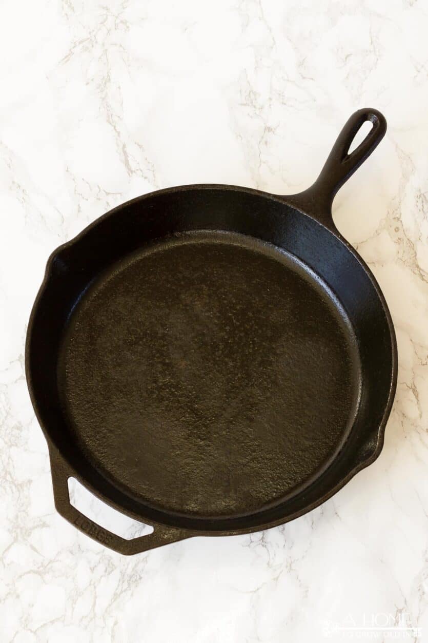 image of a cast iron skillet with areas of season scrubbed off