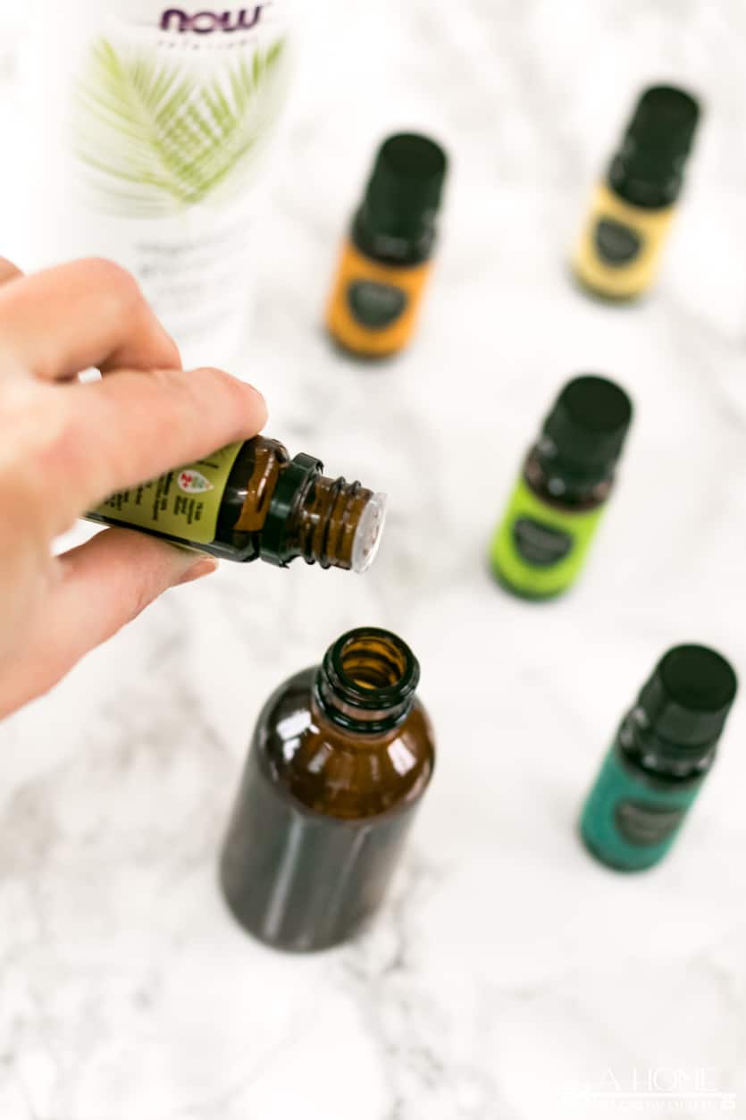 pouring essential oils in a diy toilet spray bottle