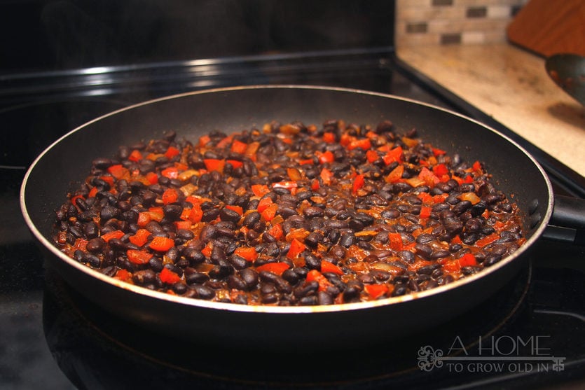 Mexican black beans sautéing on the stove